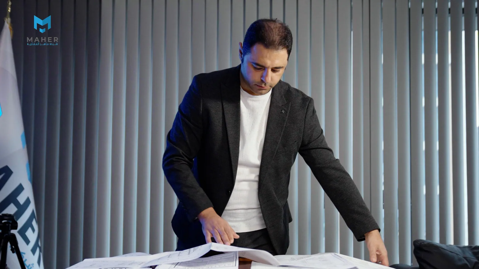 Reviewing a project's building plans beside the company flag